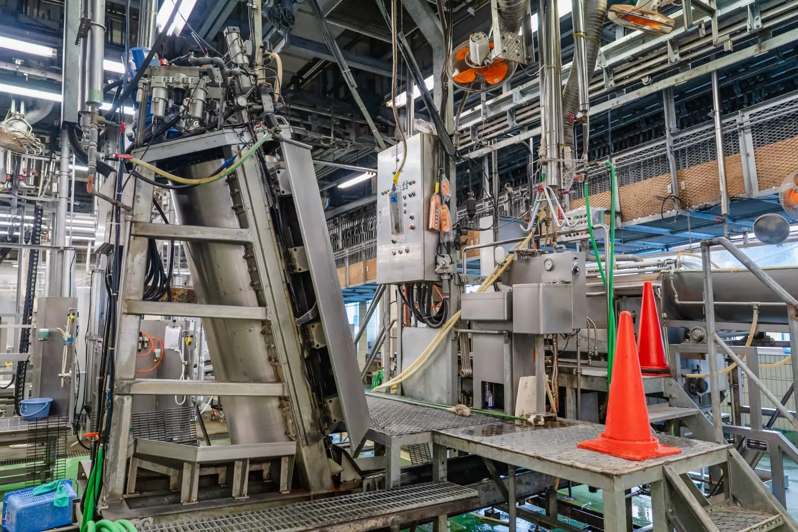 工場内の機械設備と配管が並ぶ設備エリアの様子