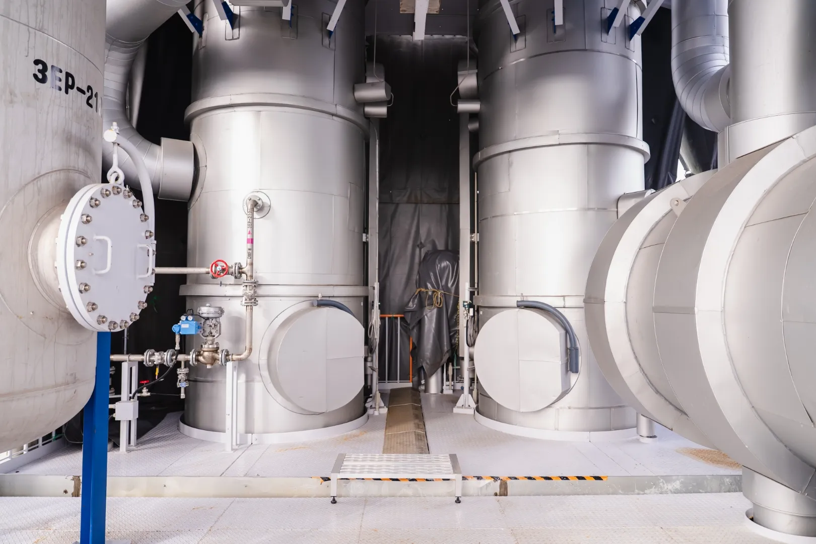 大型タンクと配管が並ぶプラント設備内部の様子
