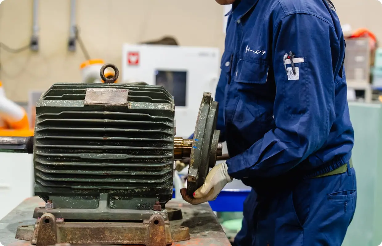 作業場で回転機を点検する作業員
