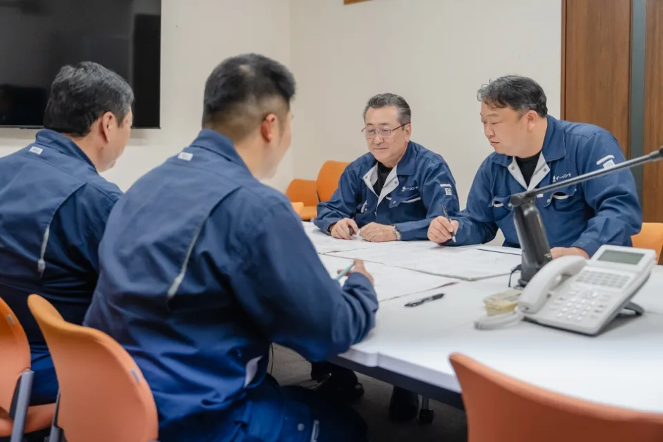 4人の社員が向かい合って話し合う様子