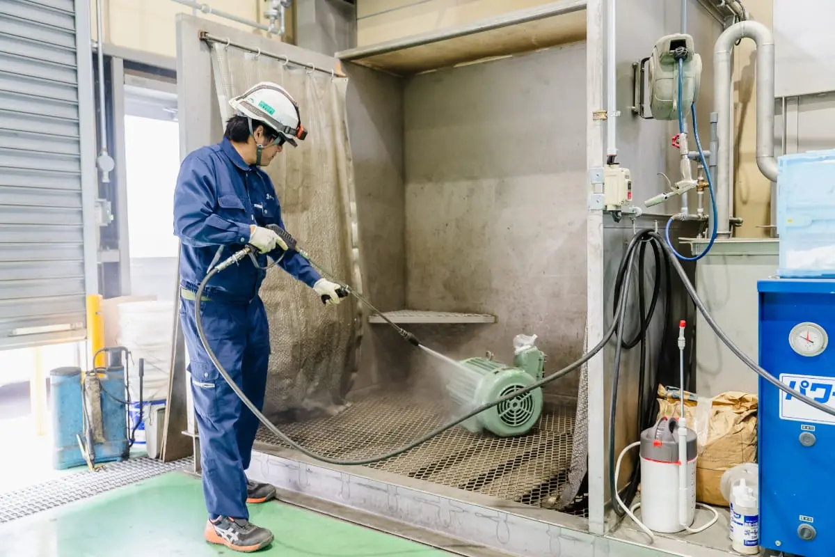 高圧洗浄機を使ってモーター部品を洗浄・清掃している様子